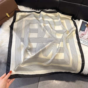 Detail of silk-feel scarf with geometric lines on soft plush background texture