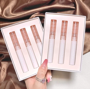 Detailed view of two mirror water lip glaze sets with cute bear caps on silk fabric