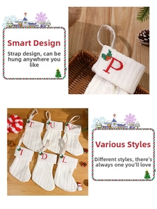 Close-up of white cable knit Christmas stocking with red letter embroidery and holly leaves