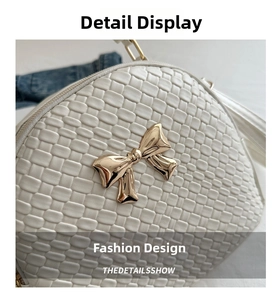 Dettaglio della borsa intrecciata bianca con fiocco metallico dorato e cerniera elegante