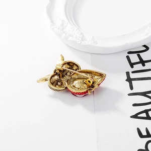 Back view of vintage owl brooch with gold alloy base and secure safety pin clasp