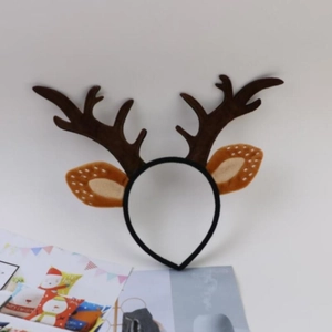 Detailed view of brown plush reindeer antlers and ears on a headband with white dots
