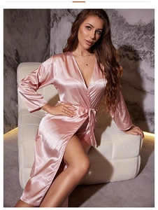 Detailed close-up of pink satin bathrobe with glossy silk texture and elegant waist tie