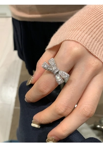 Close-up of elegant bow-shaped ring with sparkling pavé zircons on a silver metal band