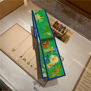 Close-up of oil painting style floral silk scarf displayed on a luxury jewelry counter