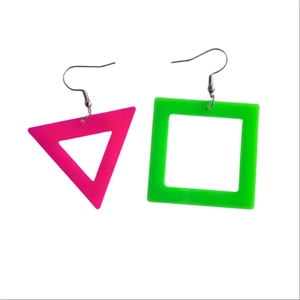 Close-up of neon pink triangle and green square geometric cutout acrylic earrings