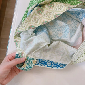 Close-up of durable stitching and colorful patchwork floral fabric on a cotton tote bag