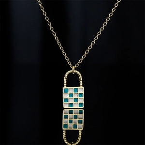 Gold chain necklace featuring a blue and white checkered enamel lock pendant on black background