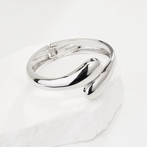 Polished silver geometric teardrop open cuff bracelet on textured stone base