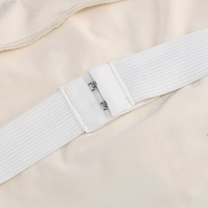 Detailed close-up of elastic bands and metal hooks on a white fishtail evening dress