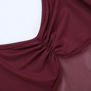 Detail of burgundy red dress with ruching and sheer mesh patchwork texture