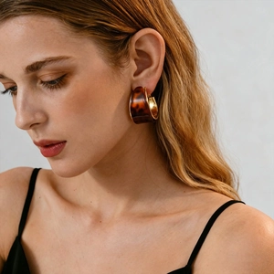 Vintage resin geometric C-shaped hoop earrings with gold metal trim on white background