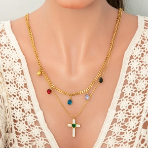 Double-layered gold necklace with cross pendant and multi-colored gemstone charms