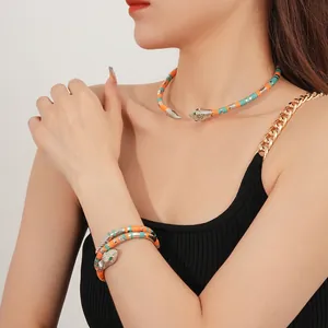 Bohemian beaded snake jewelry set featuring orange and turquoise wraps with silver heads