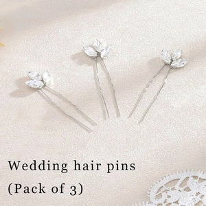 Detailed view of three silver leaf wedding hair pins with sparkling crystals on lace