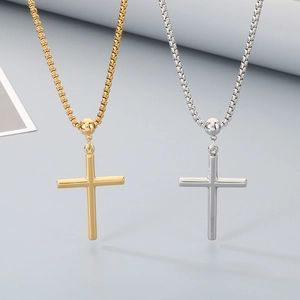 Detailed macro view of gold and silver box chain necklaces with polished cross pendants