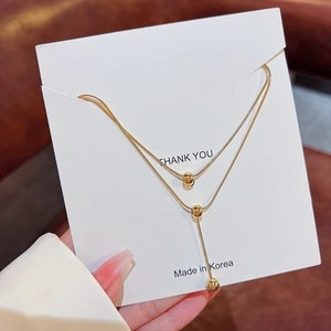 Double-layered gold teardrop Y-necklace with metallic bead pendants and sleek snake chains