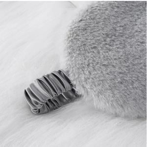 Detail of grey plush faux fur eye mask with a smooth elastic satin strap for sleep