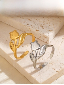 Detailed view of elegant gold and silver tulip open rings on a stone display