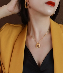 Detail of 18k gold plated irregular pendant necklace and round bead earrings on model