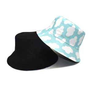 Double-sided reversible bucket hat with blue sky cloud print and solid black cotton fabric