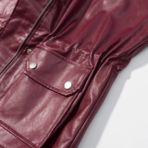 Detail of burgundy PU leather jacket featuring silver zippers, pockets and snap buttons