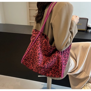 Detail of red and black leopard print tote bag styled with a khaki blazer and beige skirt