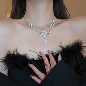 Elegant pearl choker necklace with a vintage heart pendant and sparkling crystals on neck