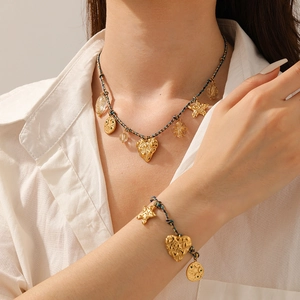 Close-up of bohemian woven cord necklace and bracelet with gold heart and star charms
