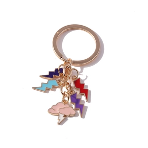 Porte-clés doré avec breloques éclair en émail coloré et nuage rose sur fond blanc