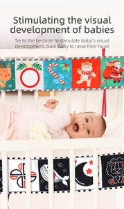 Baby crib cloth book tied to rail featuring double-sided Christmas patterns and mirror