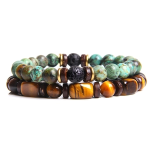 Detail of beaded bracelet set with tiger eye, turquoise and lava stones on white background