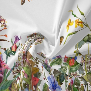 Close-up of soft bohemian fabric with vibrant watercolor floral and butterfly patterns