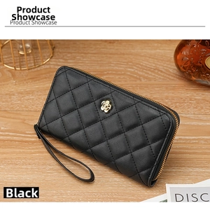 Detail of black quilted wristlet wallet with elegant golden petal clasp and leather texture