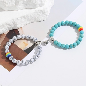 Close-up of magnetic heart clasp connecting marble and turquoise beaded bracelets
