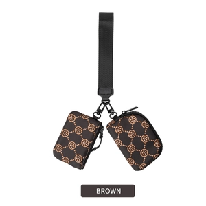 Macro view of two mini nylon wrist pouches with brown clover pattern on wide black strap
