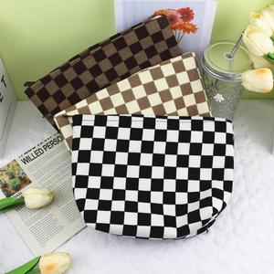 Three corduroy checkered cosmetic bags with zippers, shown with tulips and newspaper