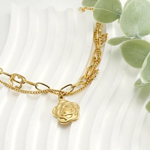 Detailed view of golden double-layer chain bracelet featuring camellia flower pendant