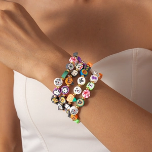 Macro detail of stacked Halloween bracelets with pumpkin, ghost and bat fimo beads
