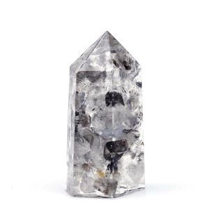 Handmade quartz crystal hexagonal pillar ornament with black inclusions on white background