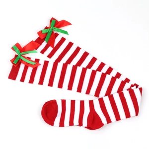 Detail of Christmas over-the-knee socks with red and white stripes and ribbon bows