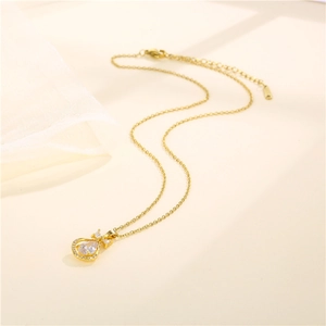 Gold stainless steel teardrop pendant necklace with white zircon stones and bow detail