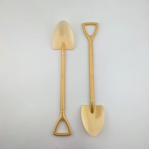 Macro shot of two mini golden shovel ornaments for Christmas DIY tree decorations