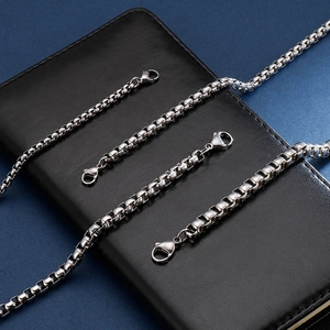 Polished silver box chain bracelet with lobster clasp on a leather texture background