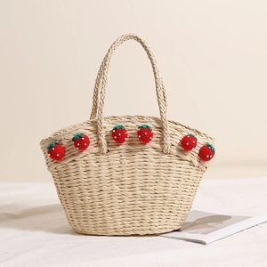 Handmade straw basket bag with red crochet strawberry patterns for beach vacations