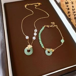 Détail du coffret collier et bracelet plaqué or avec feuilles de ginkgo et jade vert