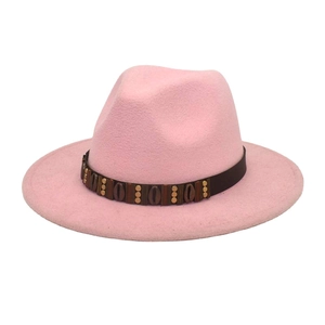 Pink wide brim fedora hat detail featuring leather belt with metallic ornaments
