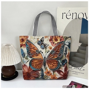 Close-up of ethnic tote bag with 3D butterfly floral embroidery and striped handles