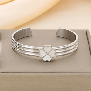 Détail d'un bracelet trèfle en acier inoxydable argenté avec nacre blanche sur écrin à bijoux
