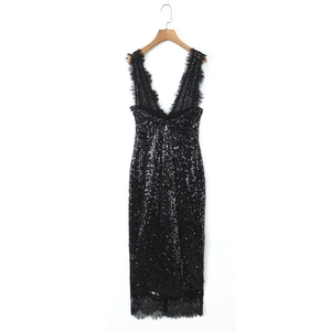 Détail d'une robe noire à paillettes avec dentelle fine et texture décolleté en V
